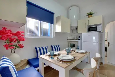 a kitchen with a table and a white refrigerator at Beach Residence Old Town in Albufeira