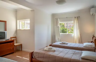 a hotel room with two beds and a television at VILAMOURA Two Bedroom Near Praia Falésia in Quarteira