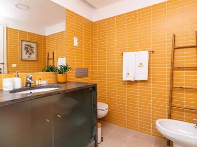 an orange tiled bathroom with a sink and a toilet at Serenity 06 House by Stay ici Algarve Holiday Rental in Albufeira