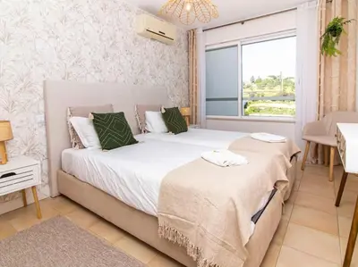 a bedroom with two beds and a window at Serenity 06 House by Stay ici Algarve Holiday Rental in Albufeira
