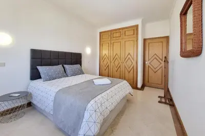 a bedroom with a bed and a wooden door at Blue Palmtree in Albufeira