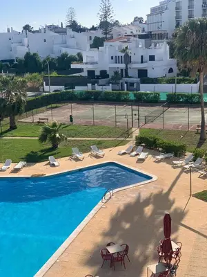 a swimming pool with chairs and tables and buildings at S Soares T1 Sil Choro in Albufeira