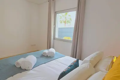 a bedroom with a bed with towels and a window at Segolene Design in Albufeira