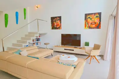 a living room with a couch and a tv at Segolene Design in Albufeira