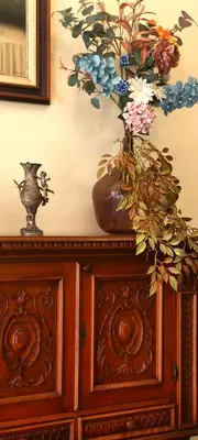 a vase with flowers on top of a wooden cabinet at Grand Studio 56 in Faro