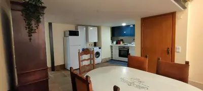 a kitchen with a table and chairs and a white refrigerator at Grand Studio 52 in Faro