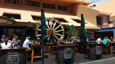 a group of people sitting at tables in front of a restaurant at Vilamoura Dream House QR2 in Quarteira