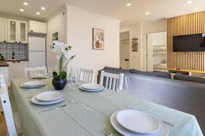 a dining room table with white plates and glasses at Cosy apartment in Albufeira, OURA ST in Albufeira