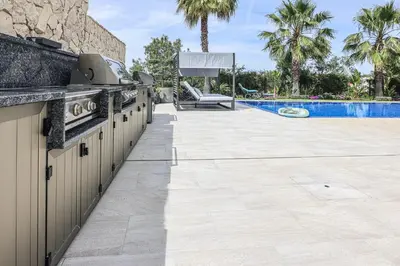 a stone retaining wall in a yard with grass at Villa Moroz - BY BEDZY in Almancil
