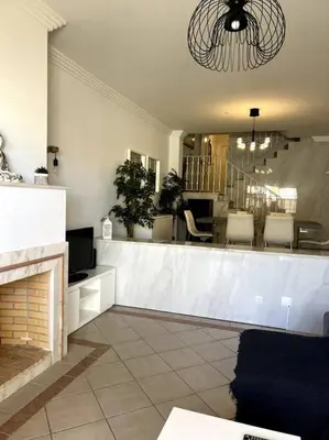 a living room with a fireplace and a bar at Moradia Almorávia in Olhos de Água