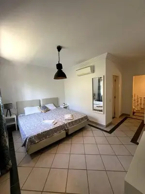 a bedroom with a bed and a tiled floor at Moradia Almorávia in Olhos de Água