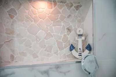 a bathroom with a stone wall and a mirror at Amelie Old Town Apartment in Albufeira