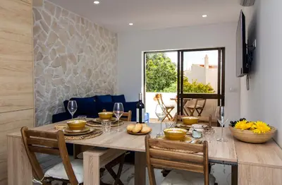 a dining room with a wooden table and chairs at Amelie Old Town Apartment in Albufeira