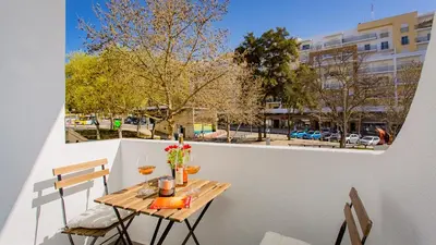 a table on a balcony with a view of a street at La Liberdad Loft in Albufeira