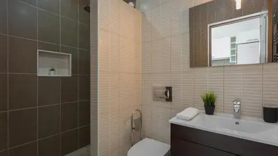 a bathroom with a toilet and a sink and a mirror at Pateo Loft in Albufeira
