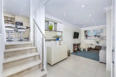 a living room with a staircase in a house at Stunning 2-Bedroom Beach Retreat in Vale do Lobo in Almancil