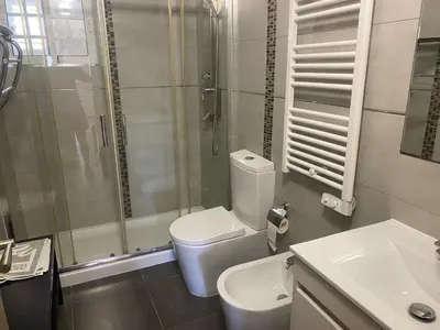 a bathroom with a shower and a toilet and a sink at Villa Albufeira 1 à 6 personnes in Guia