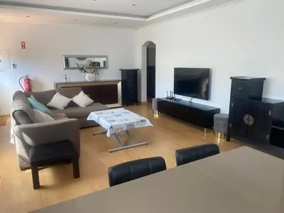 a living room with a couch and a tv at Villa Albufeira 1 à 6 personnes in Guia
