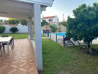 a patio with a table and chairs next to a pool at Villa Albufeira 1 à 6 personnes in Guia