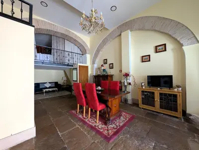 a living room with a table and red chairs at Grand Studio 27 in Faro
