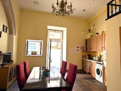 a kitchen with a dining room table and red chairs at Grand Studio 27 in Faro