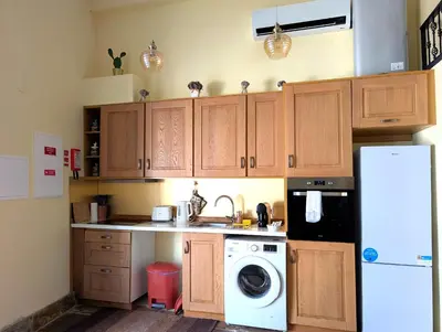 a kitchen with wooden cabinets and a washing machine at Grand Studio 27 in Faro