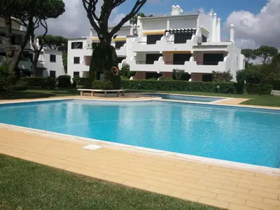 a swimming pool in front of a building at AA Apartamento Solar dos Pinheiros in Vilamoura