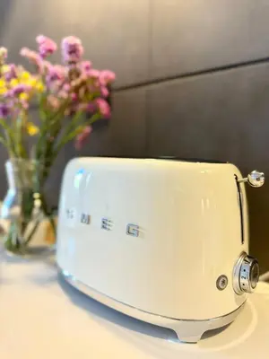 a toaster sitting on a table with a vase of flowers at Narciso Townhouse in Faro