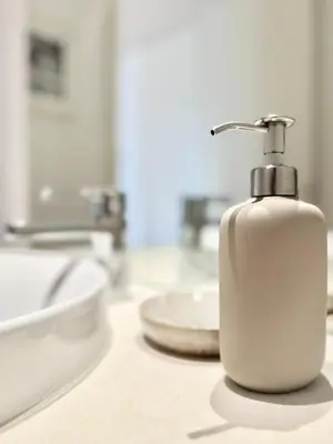 a white soap dispenser on a counter in a bathroom at Narciso Townhouse in Faro