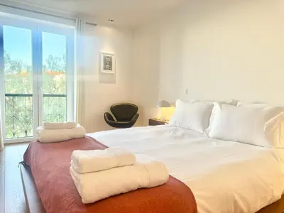 a bedroom with a large bed with two towels on it at Narciso Townhouse in Faro