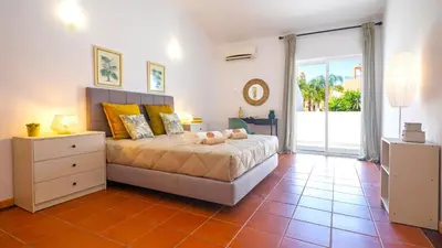 a bedroom with a bed and a large window at Villa Del Sol by Algarve Vacation in Quarteira