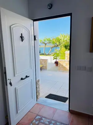an open door with a view of the ocean at Villa Cristipaulo in Praia de Faro