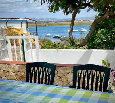a table with two chairs and a view of the water at Villa Cristipaulo in Praia de Faro