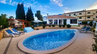 a pool in a yard with chairs and a building at Buganvilia by Check-in Portugal in Albufeira