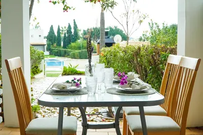 a table with plates and glasses on a patio at Villa Lychee in Guia