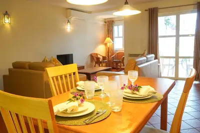 a dining room with a table and a living room at Villa Lychee in Guia