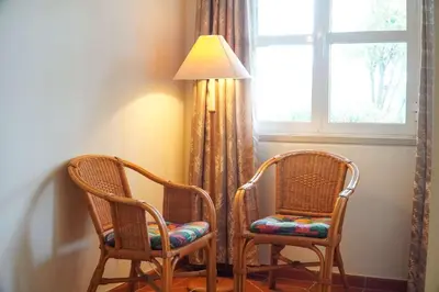 two chairs and a lamp next to a window at Villa Lychee in Guia