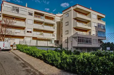 a building with a van parked in front of it at Vacation Apartment in Quarteira in Cavacos