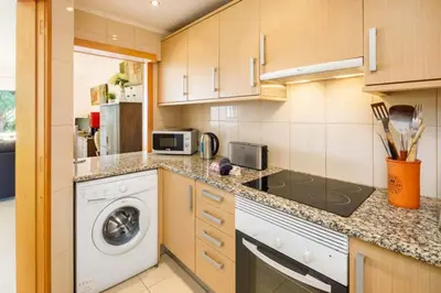 a kitchen with a washing machine and a microwave at Townhouse Flores in Faro