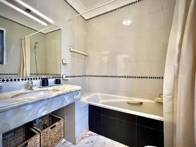 a bathroom with a tub and a sink and a mirror at Vilamoura Central 8 by Homing in Vilamoura