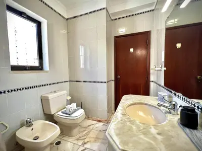 a white bathroom with a toilet and a sink at Vilamoura Central 8 by Homing in Vilamoura