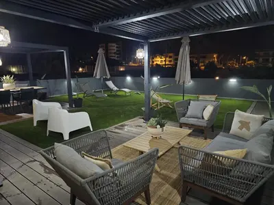 a patio with chairs and a couch and a table at Paraíso Forte Novo in Quarteira