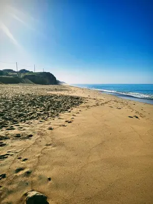 a beach with footprints in the sand and the ocean at Paraíso Forte Novo in Quarteira