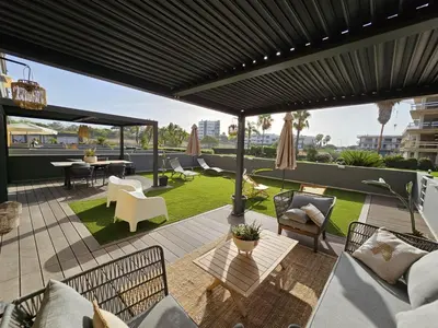 a patio with couches and a table and chairs at Paraíso Forte Novo in Quarteira