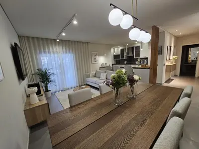 a living room with a dining table and a living room at Paraíso Forte Novo in Quarteira