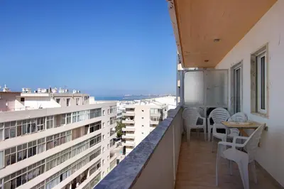 a balcony with chairs and a table on a building at Moderno e acolhedor com vista mar in Quarteira