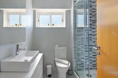 a bathroom with a sink toilet and a glass shower at Moderno e acolhedor com vista mar in Quarteira
