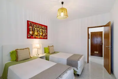 a bedroom with two beds and a painting on the wall at T1 com vista mar in Quarteira