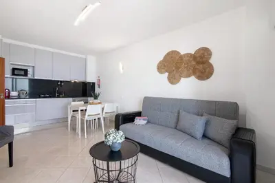 a living room with a couch and a table at T1 com vista mar in Quarteira