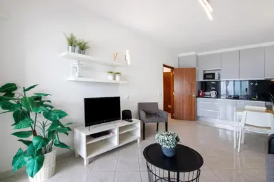 a living room with a tv and a table at T1 com vista mar in Quarteira